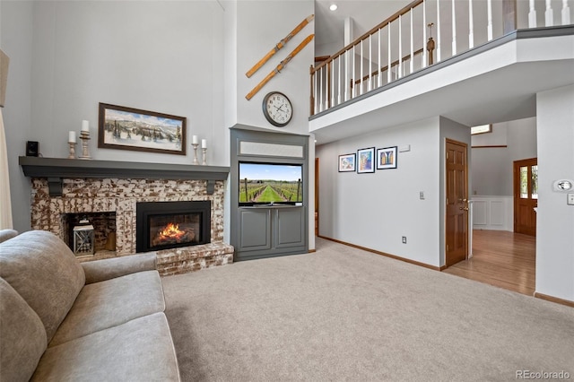 4161 W Lake Cir N, Littleton, CO 80123 - living area featuring carpet, a brick fireplace, a high ceiling, healthy amount of natural light, and baseboards