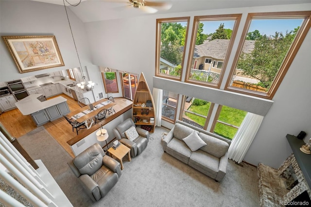 4161 W Lake Cir N, Littleton, CO 80123 - living area featuring a high ceiling, healthy amount of natural light, ceiling fan, a chandelier, and wood finished floors
