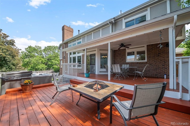 4161 W Lake Cir N, Littleton, CO 80123 - wooden deck featuring a hot tub, outdoor dining space, a ceiling fan, and an outdoor fire pit