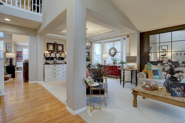 living room featuring baseboards, wood finished floors, a notable chandelier, and a raised ceiling