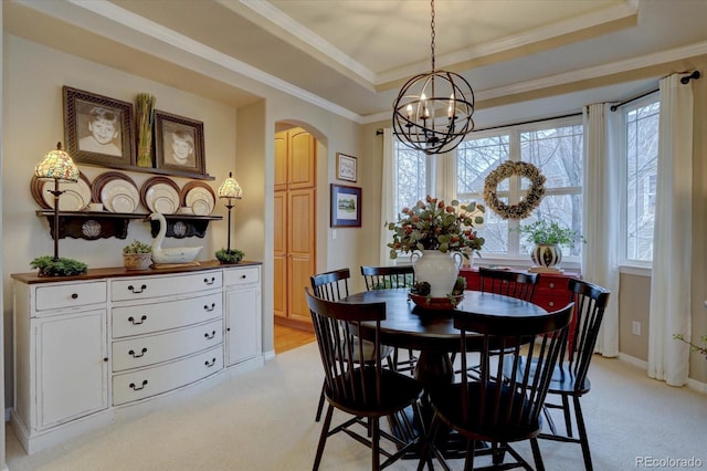 dining area featuring a raised ceiling, plenty of natural light, arched walkways, and a chandelier