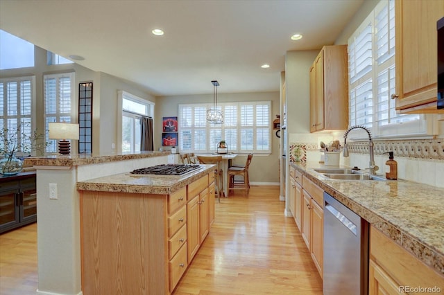 kitchen with a sink, light brown cabinetry, light countertops, and appliances with stainless steel finishes