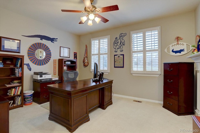 office featuring light colored carpet, visible vents, baseboards, and a ceiling fan