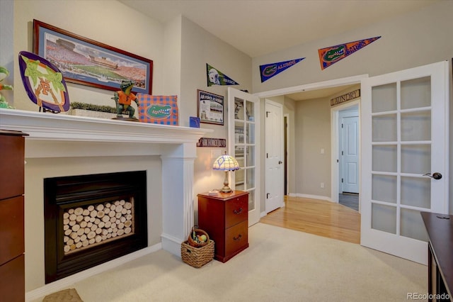 living room with baseboards, a fireplace, carpet floors, and french doors