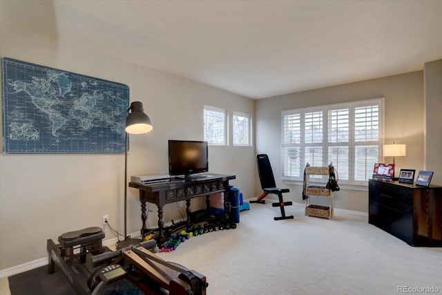 workout room featuring carpet and baseboards
