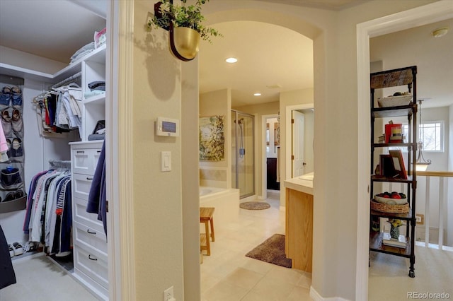 spacious closet featuring arched walkways