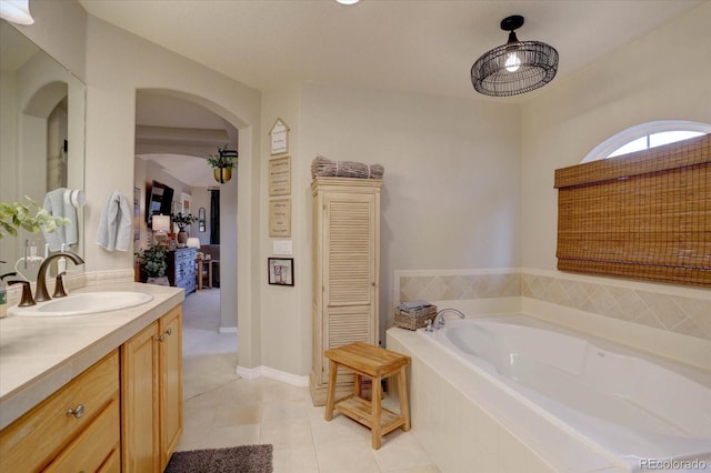 bathroom with a bath, baseboards, tile patterned flooring, and vanity