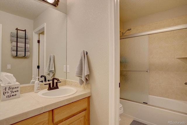 full bath with toilet, vanity, a textured ceiling, enclosed tub / shower combo, and tile patterned flooring