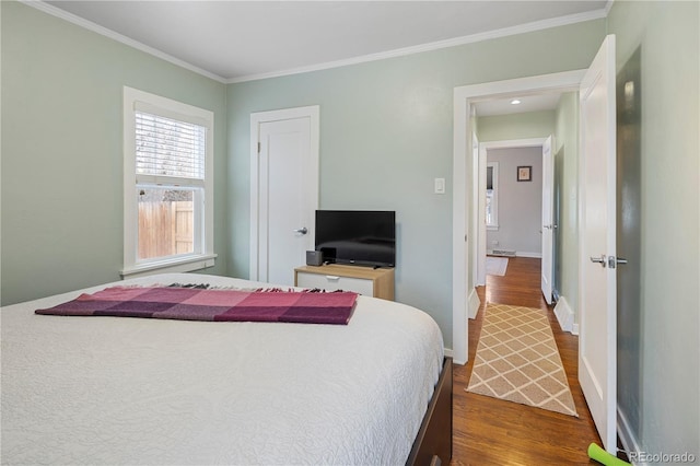 bedroom featuring baseboards, dark wood-style flooring, and ornamental molding