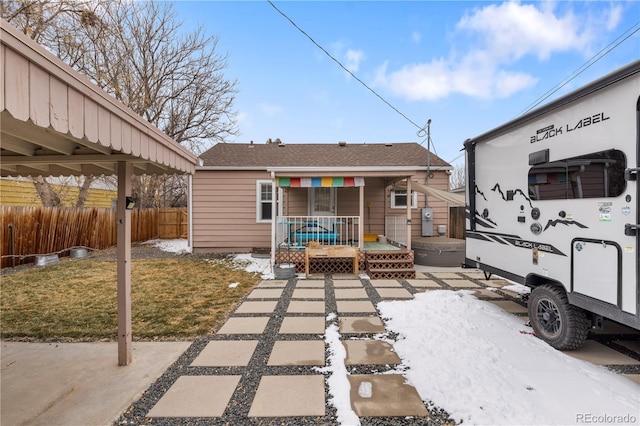 back of property with a shingled roof, a yard, a wooden deck, and fence