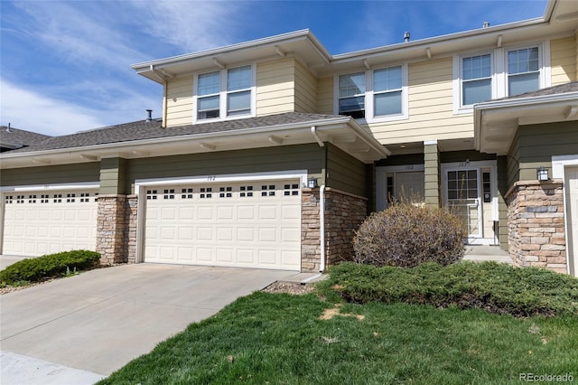 3000 E 112th Ave Unit 102, Northglenn, CO 80233 - view of front of property featuring driveway, stone siding, and an attached garage