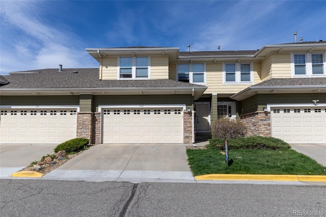 3000 E 112th Ave Unit 102, Northglenn, CO 80233 - view of front facade featuring stone siding, a garage, and concrete driveway