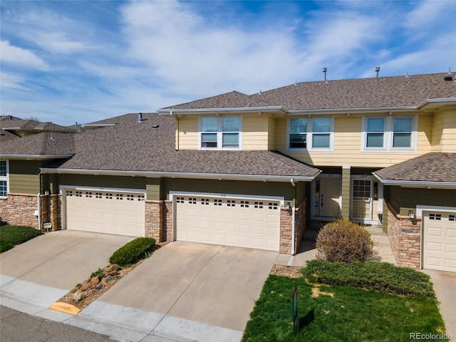 3000 E 112th Ave Unit 102, Northglenn, CO 80233 - view of front of property with concrete driveway, a shingled roof, and stone siding