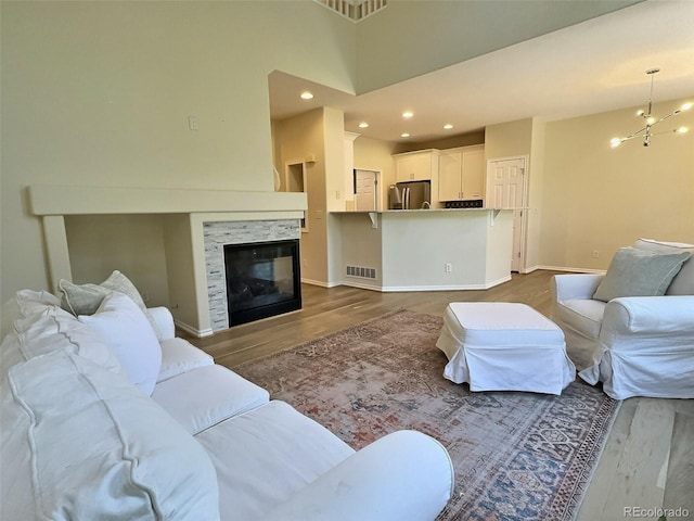3000 E 112th Ave Unit 102, Northglenn, CO 80233 - living room with dark wood-style flooring, a tiled fireplace, recessed lighting, and a chandelier
