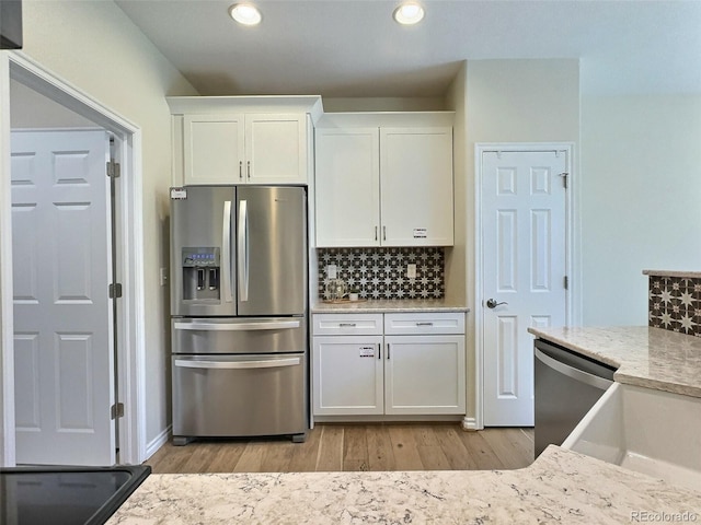 3000 E 112th Ave Unit 102, Northglenn, CO 80233 - kitchen featuring appliances with stainless steel finishes, light wood-style floors, white cabinetry, backsplash, and recessed lighting