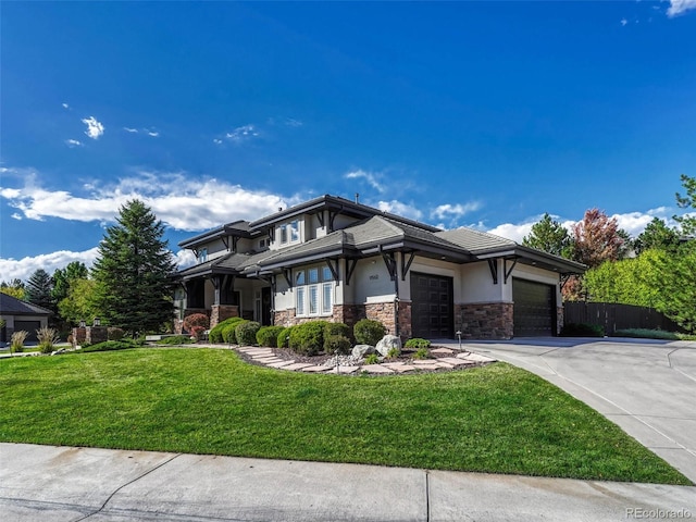 prairie-style house featuring a garage and a front lawn