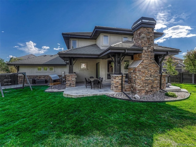 rear view of house with a patio area, a hot tub, and a lawn