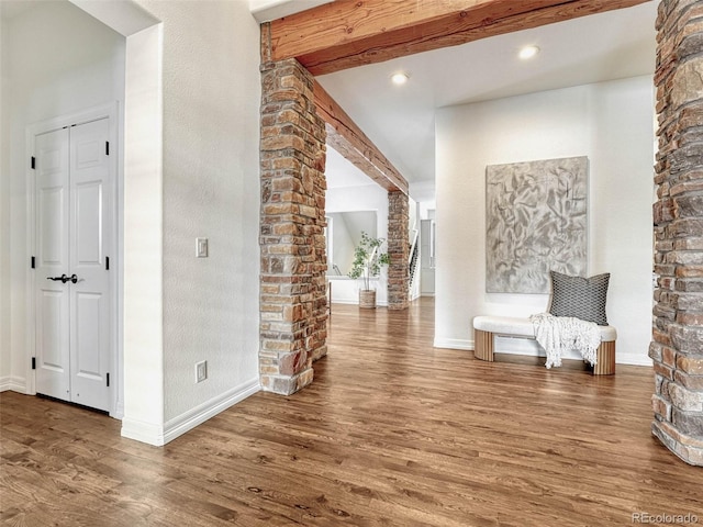 hall with wood-type flooring and beam ceiling