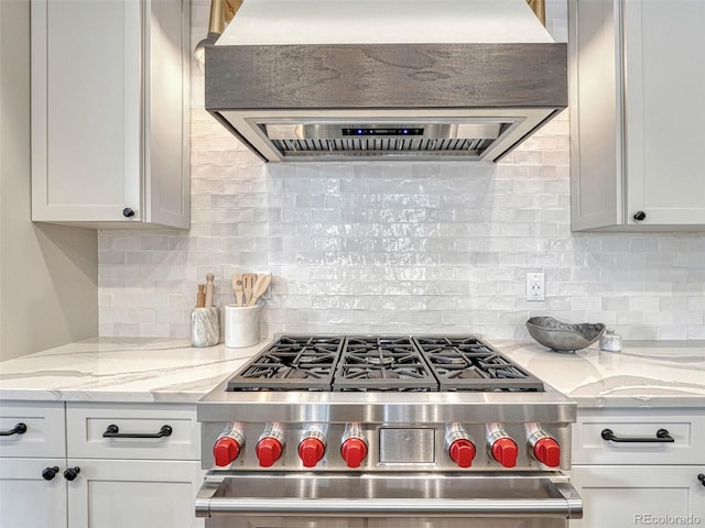 kitchen with custom exhaust hood, high end stainless steel range oven, backsplash, and white cabinets