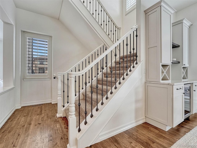 stairs with wood-type flooring and beverage cooler