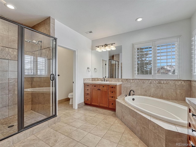 full bathroom featuring toilet, tile patterned floors, vanity, and separate shower and tub