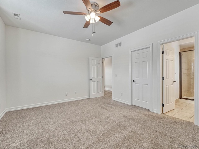 unfurnished bedroom featuring light colored carpet, connected bathroom, and ceiling fan