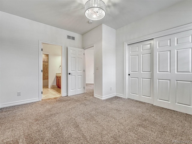 unfurnished bedroom with a closet and light colored carpet