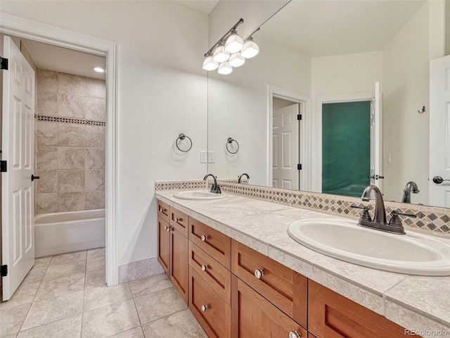 bathroom featuring tiled shower / bath and vanity