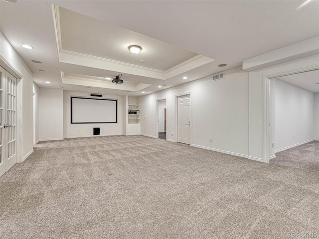 home theater with light carpet, ornamental molding, and a raised ceiling