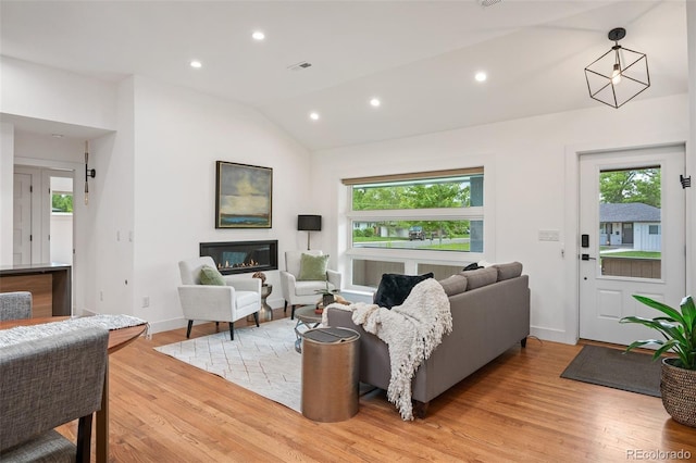2998 S Adams St, Denver, CO 80210 - living area with plenty of natural light, vaulted ceiling, light wood finished floors, recessed lighting, and a glass covered fireplace
