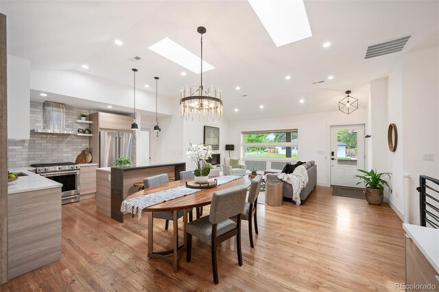 2998 S Adams St, Denver, CO 80210 - dining room with a skylight, lofted ceiling, light wood-style flooring, a chandelier, and recessed lighting