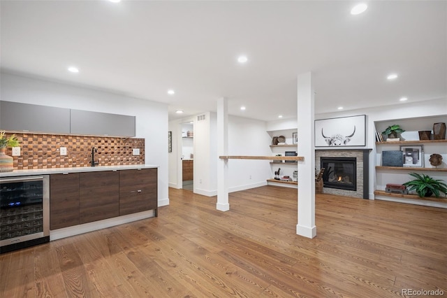 2998 S Adams St, Denver, CO 80210 - indoor wet bar featuring wine cooler, a glass covered fireplace, tasteful backsplash, light wood-style flooring, and recessed lighting