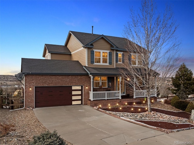 view of front of property with a garage, a porch, concrete driveway, and brick siding