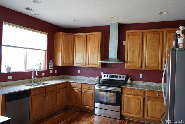 9616 Nucla St, Commerce City, CO 80022 - kitchen with appliances with stainless steel finishes, wall chimney range hood, a sink, brown cabinets, and recessed lighting