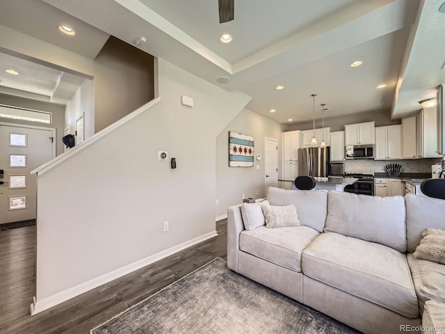 living room featuring stairway, baseboards, dark wood-type flooring, and recessed lighting