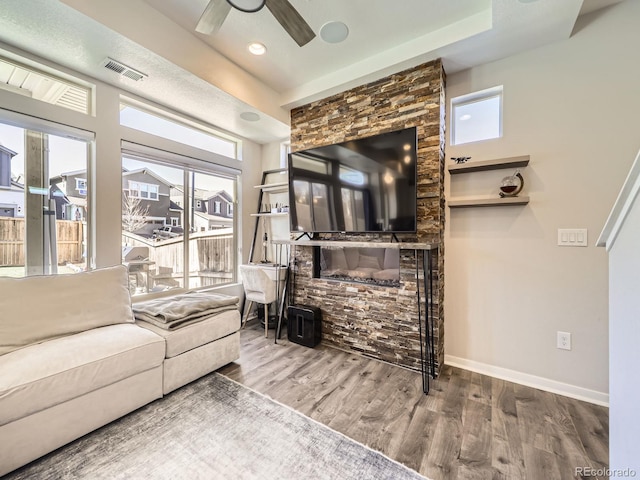 living room featuring plenty of natural light, wood finished floors, visible vents, and baseboards