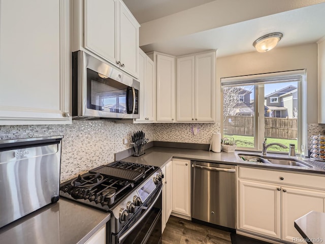 kitchen with a sink, dark wood-type flooring, stainless steel appliances, and backsplash