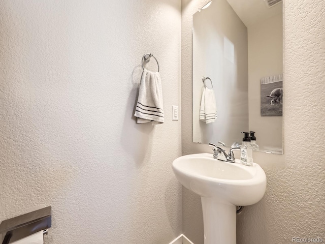 bathroom featuring a textured wall