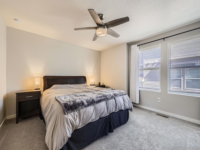 bedroom featuring baseboards, visible vents, a ceiling fan, a textured ceiling, and carpet flooring