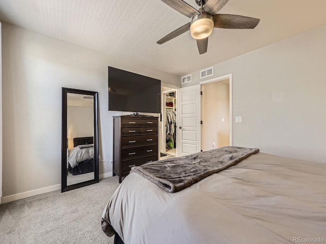 bedroom with light colored carpet, a closet, visible vents, and a spacious closet