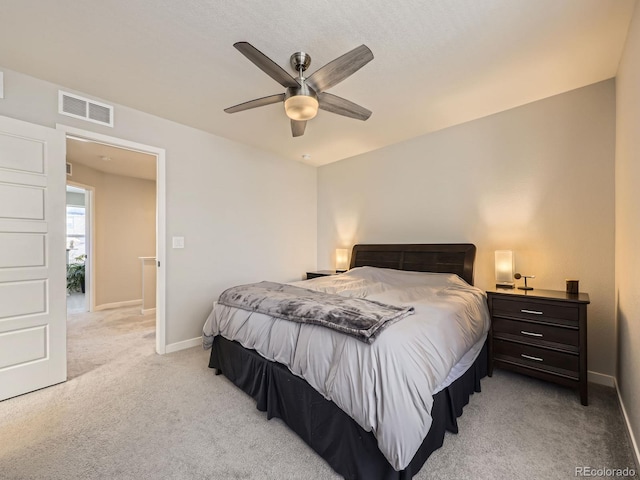 bedroom with light carpet, ceiling fan, visible vents, and baseboards