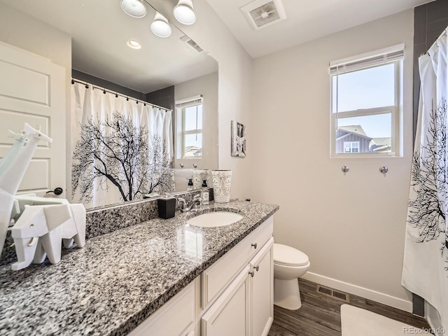 full bathroom featuring toilet, wood finished floors, visible vents, vanity, and baseboards