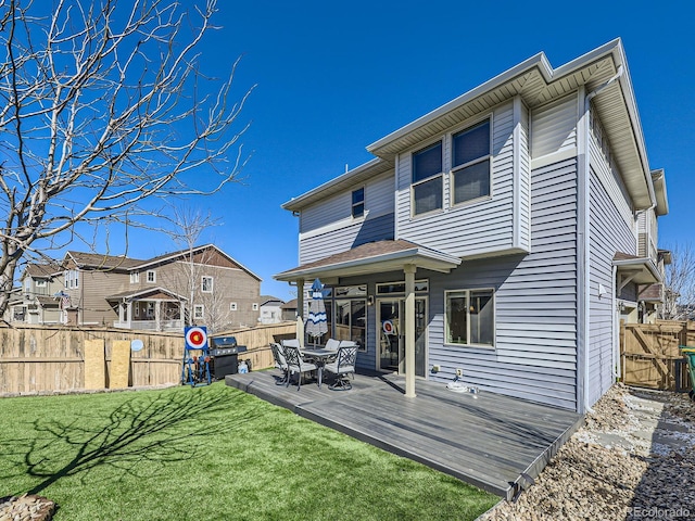 rear view of house featuring a lawn, a residential view, a fenced backyard, and a wooden deck