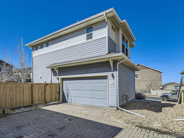 view of property exterior featuring a garage and fence