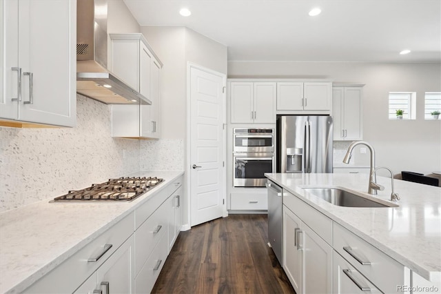 10557 Eby Cir, Lone Tree, CO 80124 - kitchen with appliances with stainless steel finishes, wall chimney exhaust hood, dark wood-style floors, white cabinets, and recessed lighting