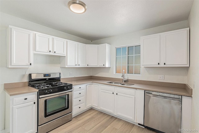 kitchen featuring white cabinetry, sink, light hardwood / wood-style flooring, and stainless steel appliances