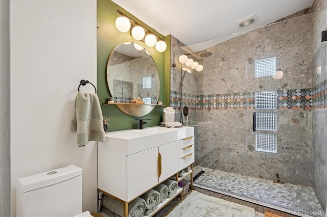 3895 Chimayo Rd, Littleton, CO 80123 - bathroom with toilet, visible vents, a tile shower, and vanity