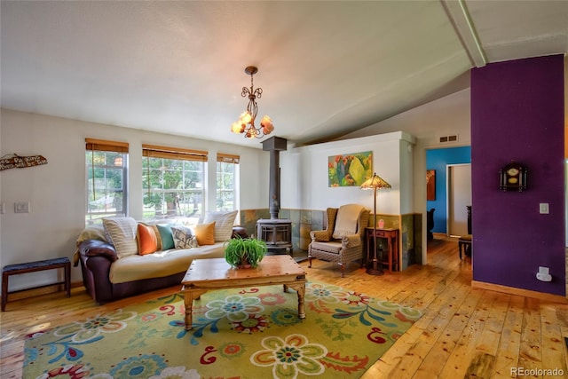 166 Ski Doo Rd, Fairplay, CO 80440 - living room with a wood stove, lofted ceiling, light wood-type flooring, a chandelier, and baseboards