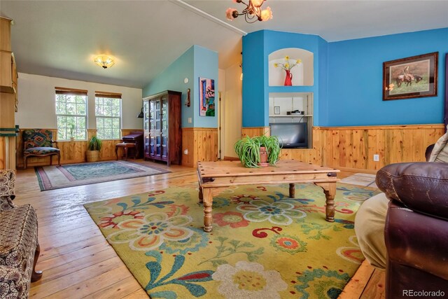166 Ski Doo Rd, Fairplay, CO 80440 - living room with a wainscoted wall, wooden walls, wood-type flooring, lofted ceiling, and a chandelier