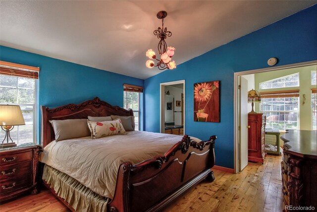 166 Ski Doo Rd, Fairplay, CO 80440 - bedroom with lofted ceiling, a chandelier, hardwood / wood-style floors, and baseboards